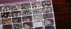 A close-up view of a neatly organized box filled with diverse crafting beads in compartments.