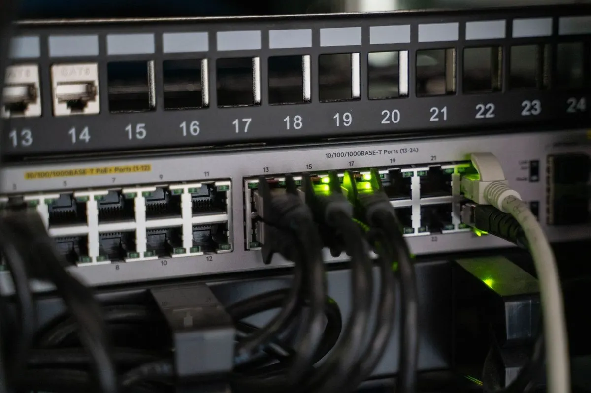 Zbliżenie na switch sieciowy z podłączonymi kablami i zielonymi diodami — Konfiguracja agregacji łączy internetowych (load balancing)