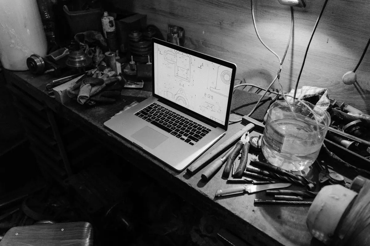 Laptop i narzędzia serwisowe na biurku, zdjęcie czarno-białe — Sprzęt firmowy naprawiany u klienta — w skrócie