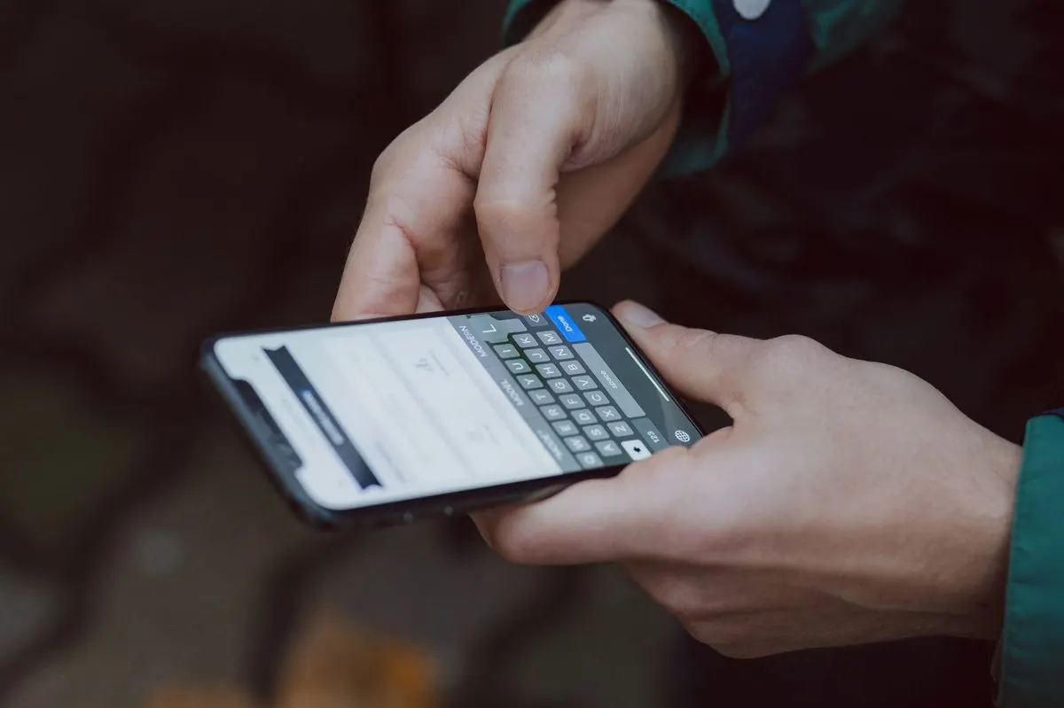 Dłonie piszące wiadomość na telefonie — Czy mogę zgłosić awarię dla kogoś innego bez jego obecności