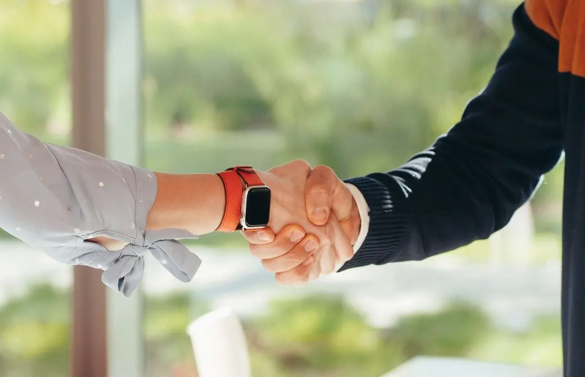 Uścisk dłoni, jedna osoba w zegarku typu smartwatch — Przygotowanie sklepu pod program partnerski (afiliacyjny) od startu