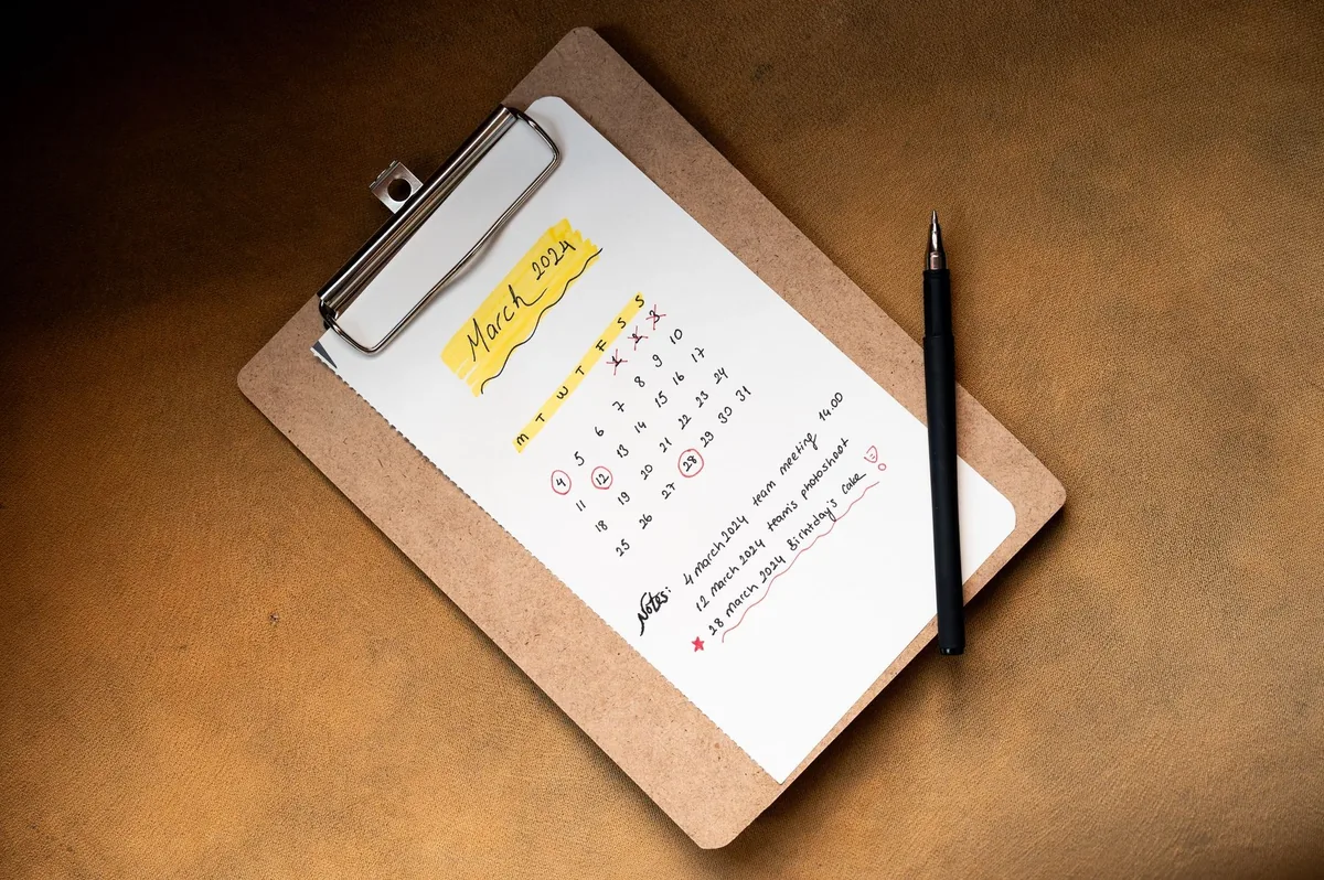 Top view of a March 2024 calendar on a clipboard with a pen, ideal for planning or scheduling content.