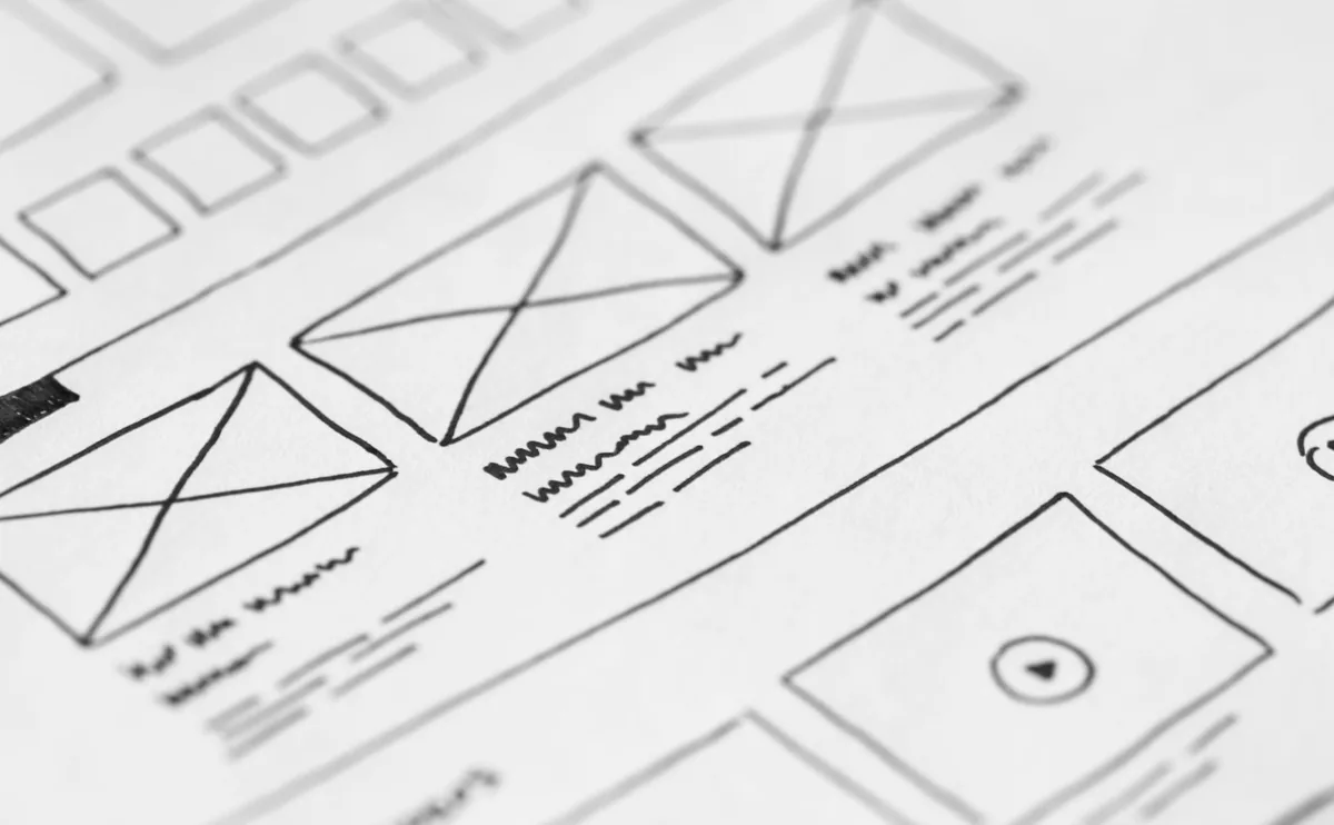 Detailed close-up of a hand-drawn wireframe design on paper for a UX project.