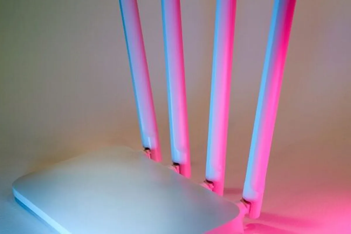 router WiFi z antenami podświetlony na różowo-niebiesko