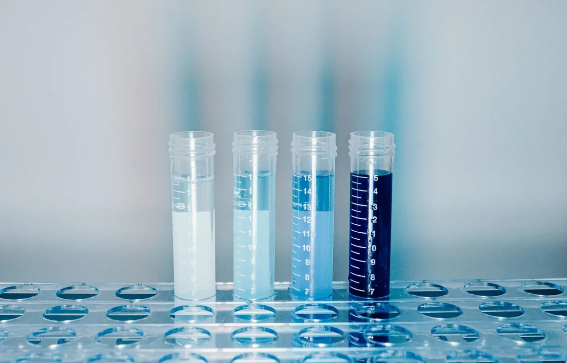 Close-up of test tubes filled with colorful liquids in a laboratory setting.