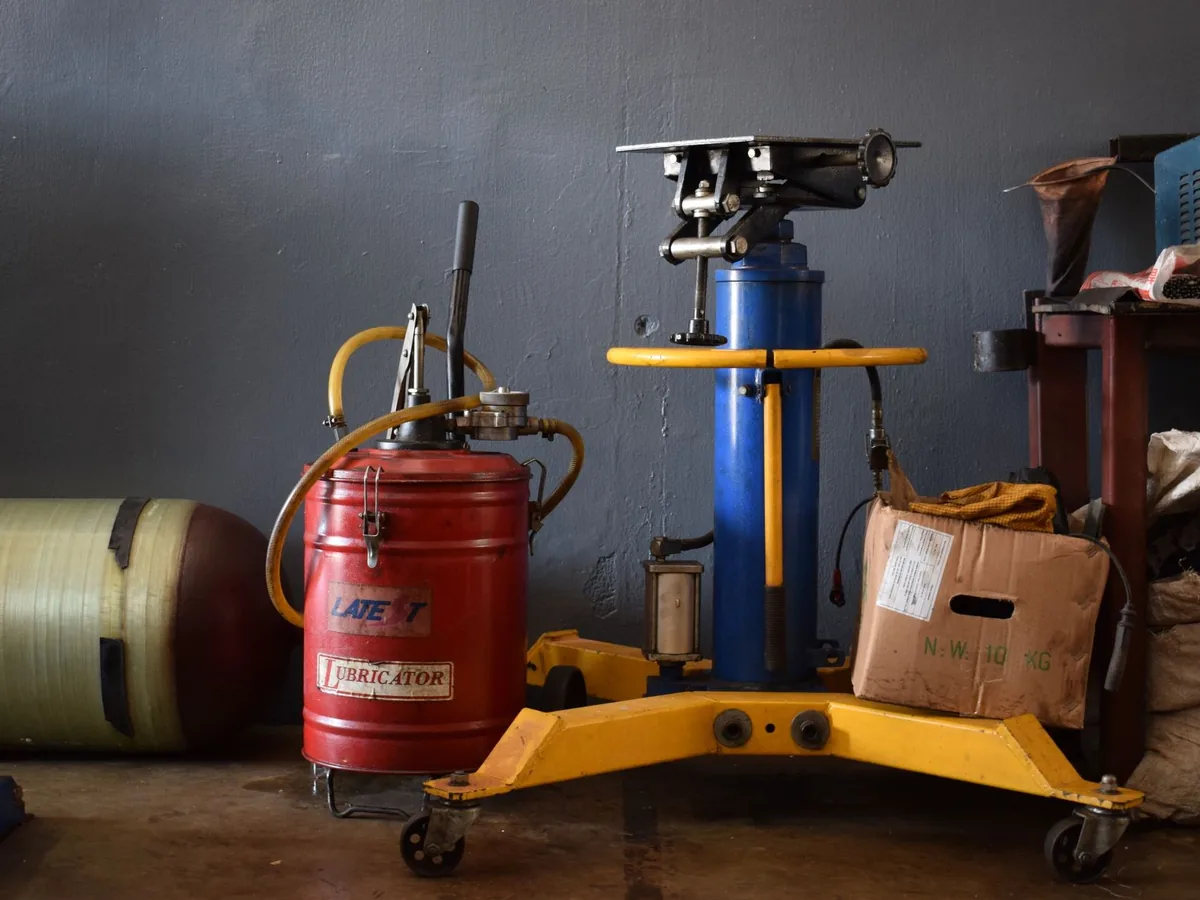 A well-equipped workshop features various machinery and an industrial lubricator.