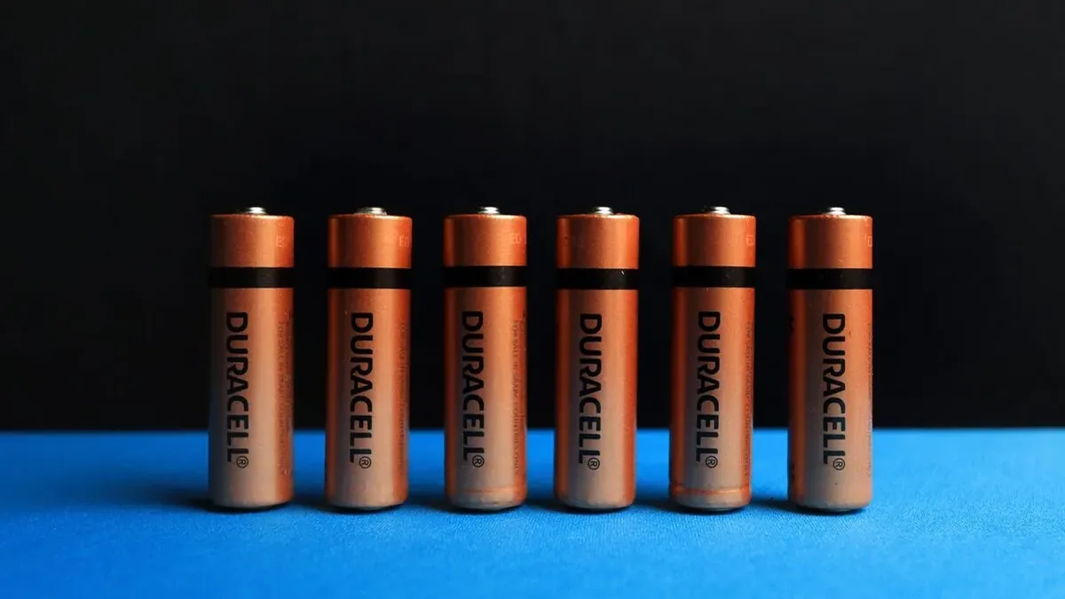 Sześć baterii Duracell ustawionych rzędem na niebieskim tle