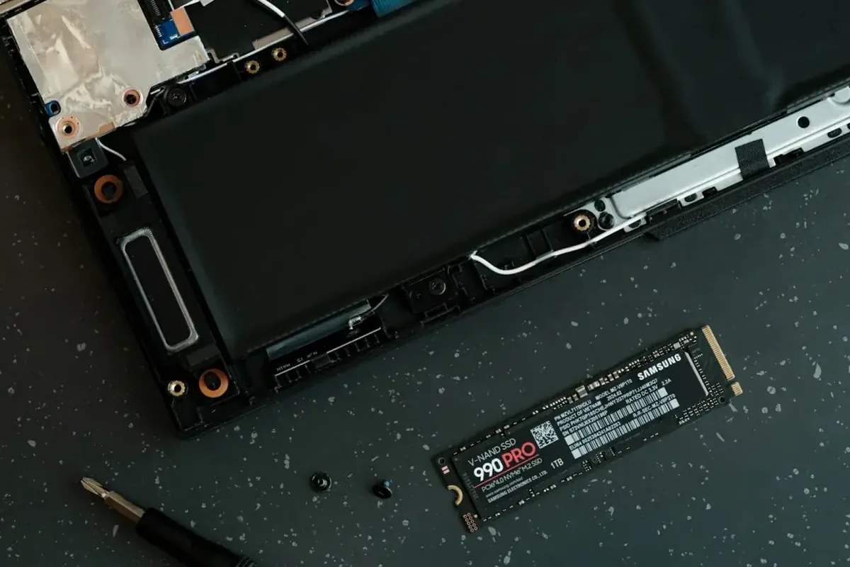 Wnętrze laptopa z zamontowanym dyskiem SSD Samsung 990 PRO obok baterii