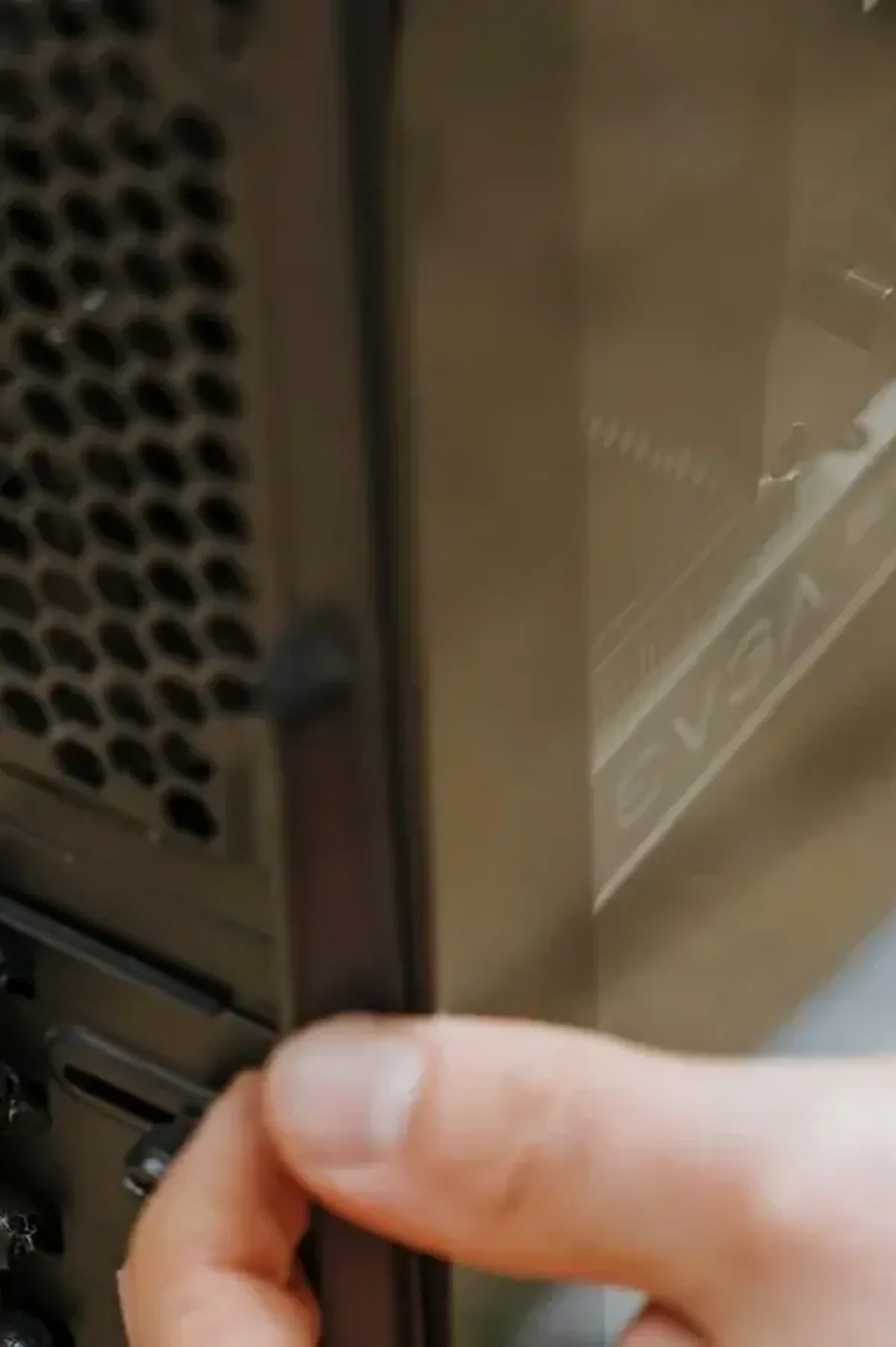 Dłoń przy tylnym panelu obudowy PC z widoczną kartą graficzną EVGA