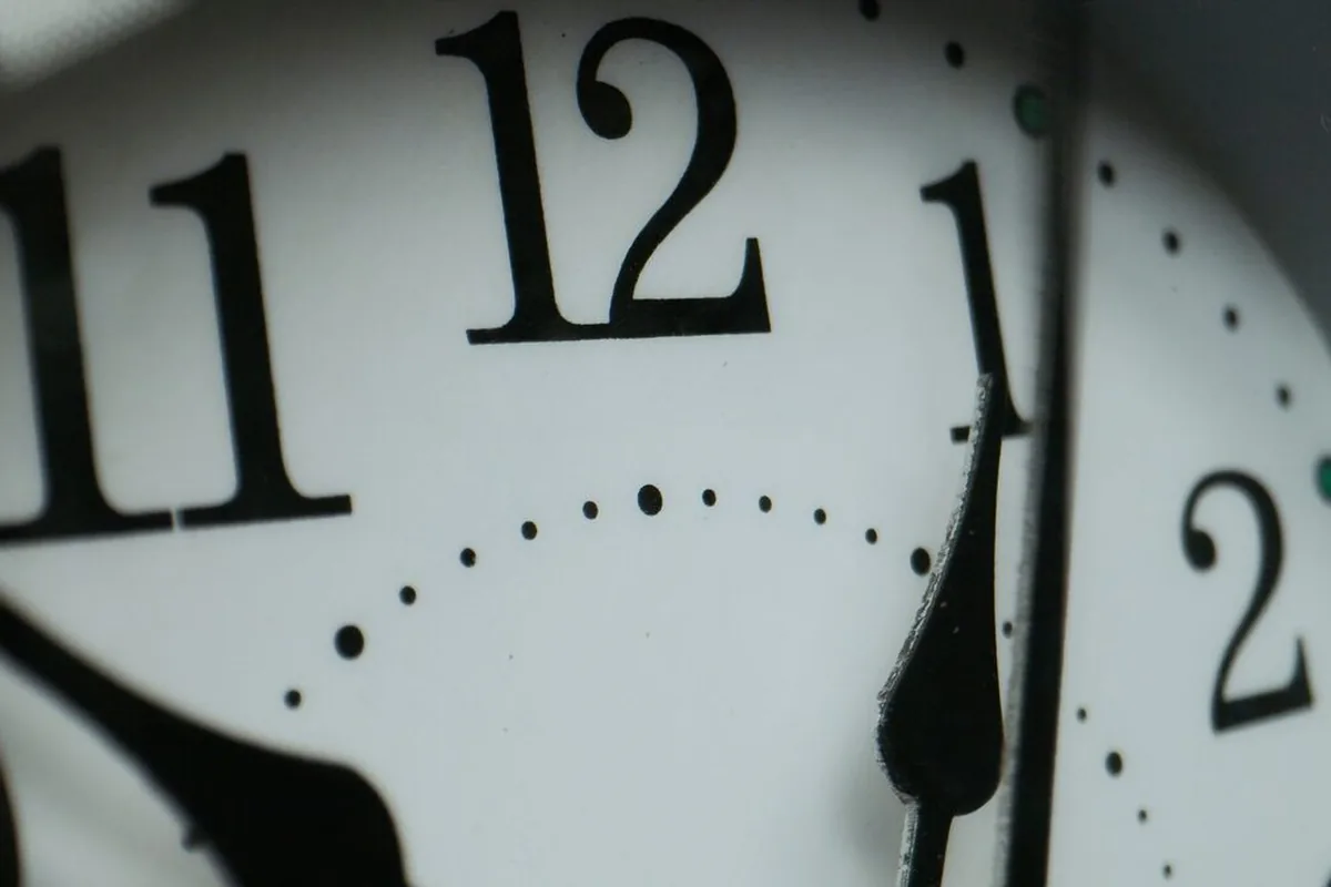 Zbliżenie na tarczę zegara z cyframi 11, 12, 1, 2