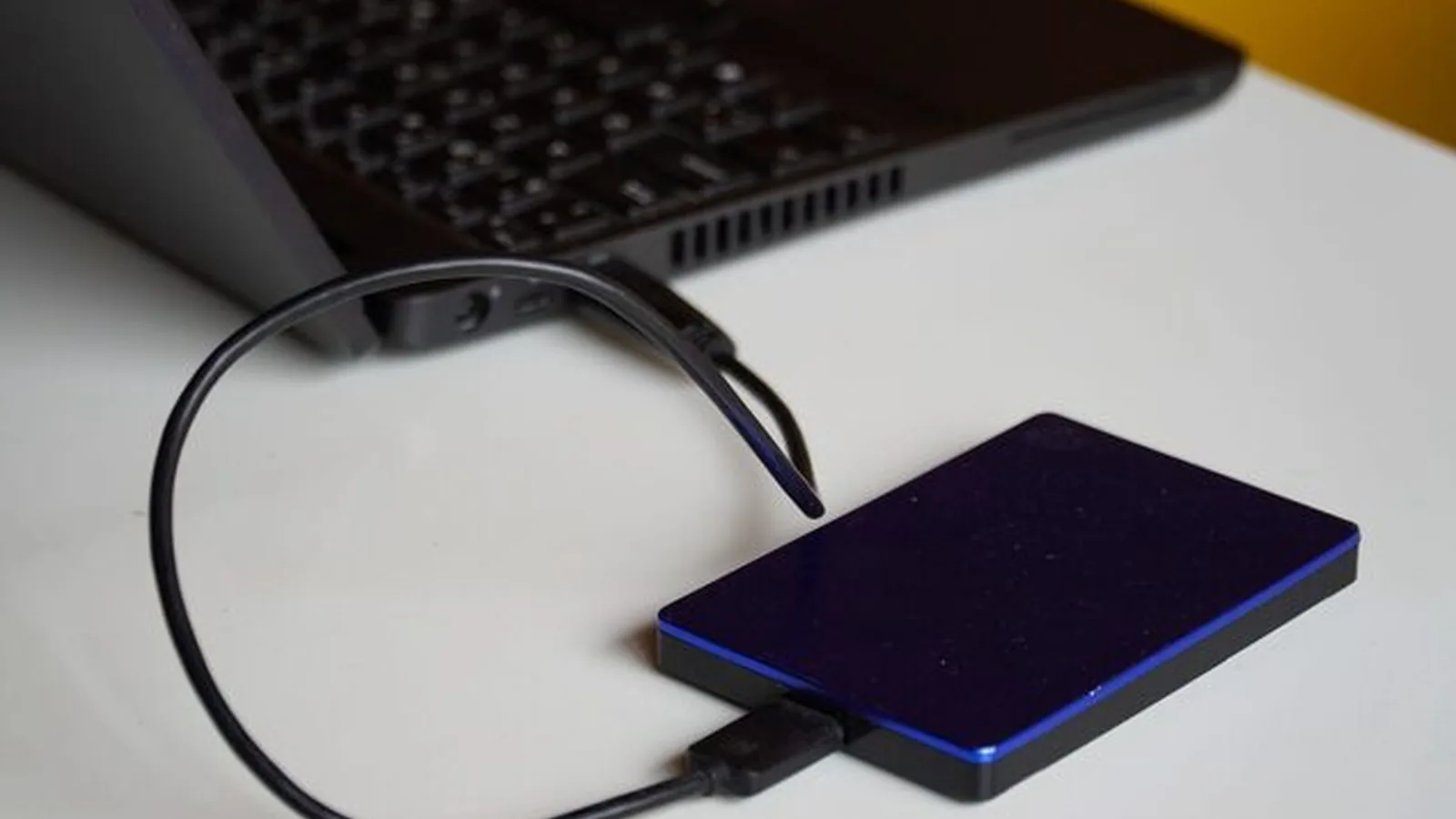 Zewnętrzny dysk podłączony kablem do klawiatury laptopa