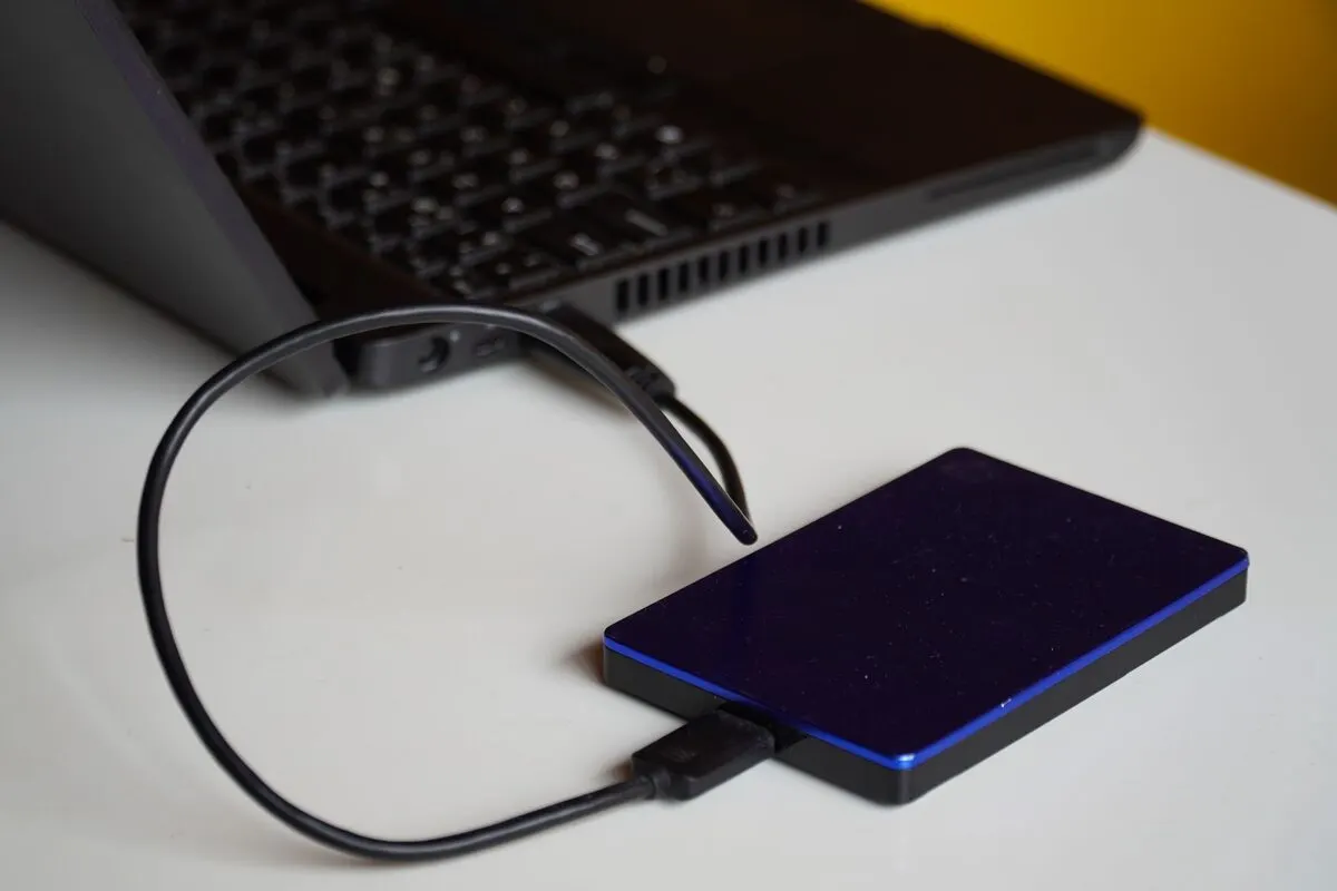 Zewnętrzny dysk przenośny podłączony kablem USB do laptopa — Przenoszenie profilu i ustawień użytkownika na nowy komputer
