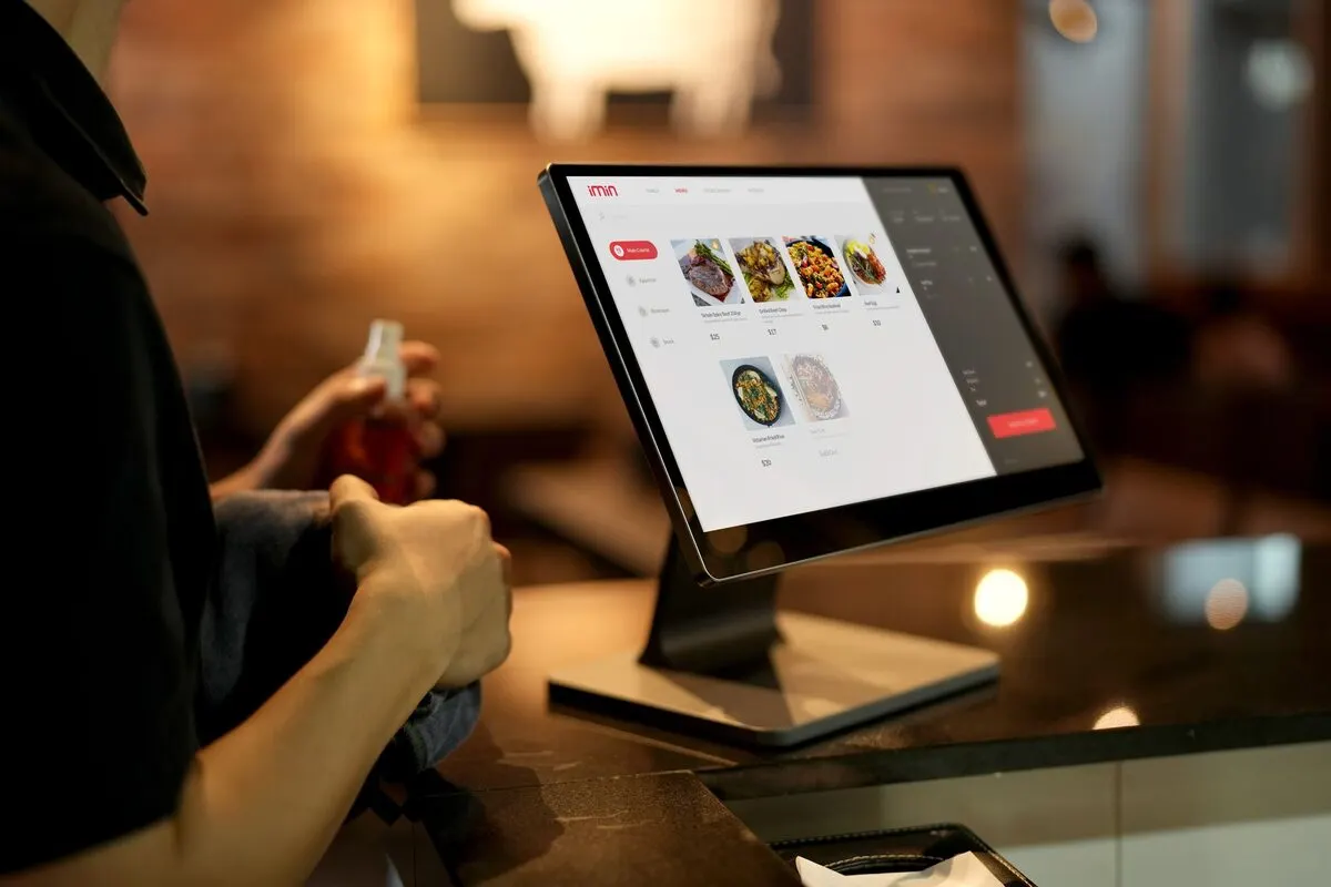 Ekran systemu POS z menu restauracyjnym obsługiwany przy kasie — Obsługa zamówień z wielu platform w jednym systemie