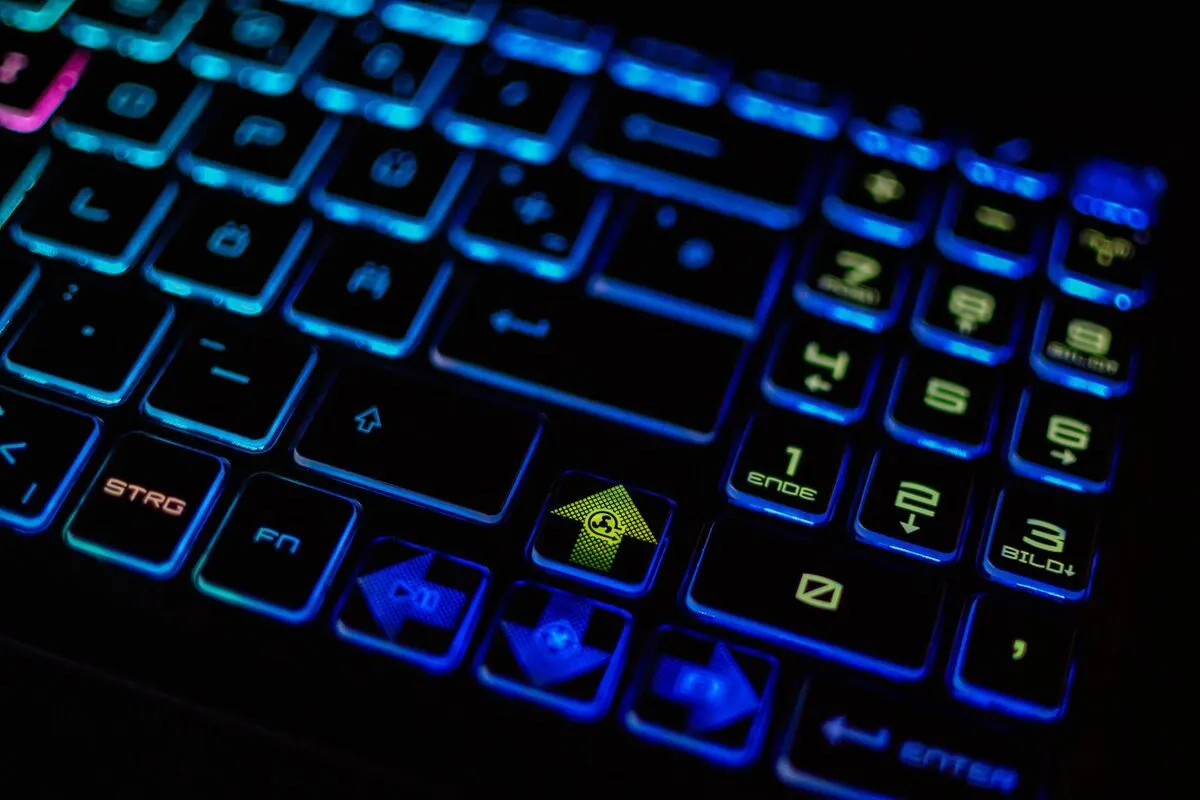 Zbliżenie podświetlanej na niebiesko klawiatury gamingowego laptopa — Specjalizujemy się w naprawach laptopów gamingowych o wysokiej mocy