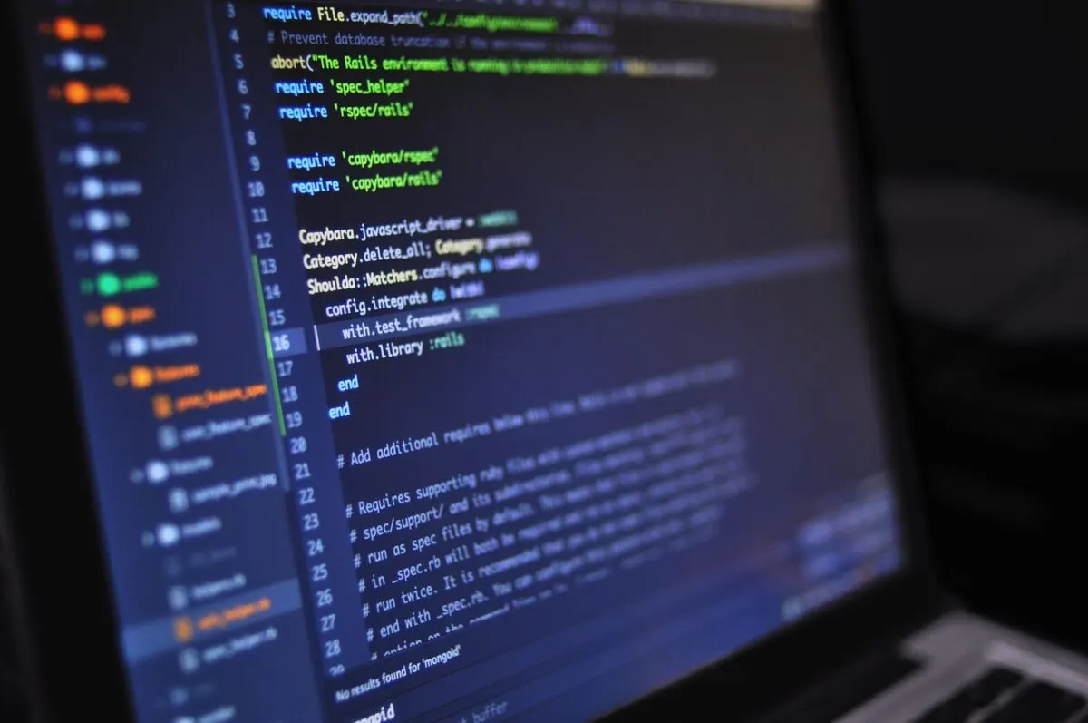 zbliżenie na ekran laptopa z kodem programistycznym (Ruby, testy) — Zgłoszenie kilku usterek naraz — jak to usprawnić